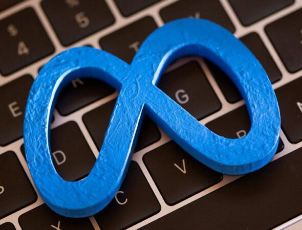 A 3D printed Facebook's new rebrand logo Meta is placed on laptop keyboard in this illustration