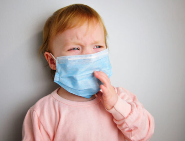 One,Healthy,Little,Baby,Crying.,Medical,Mask,On,The,Baby.