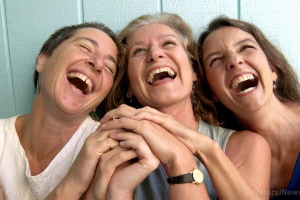Woman-Friends-Laughing-Hold-Hands
